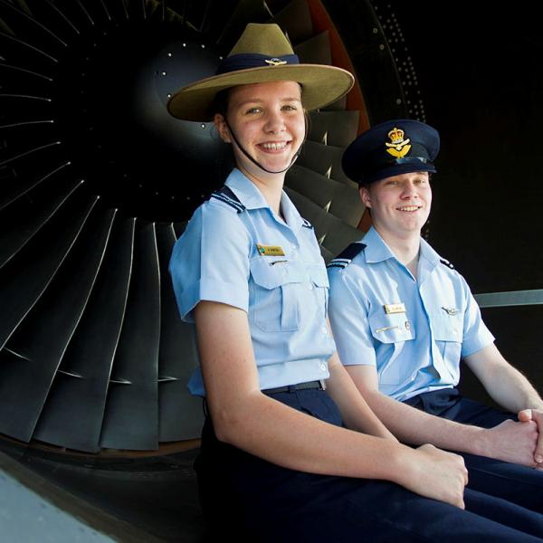 Two cadets sitting at a plane nozzle