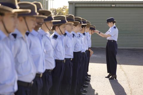 Staff Member adjusting hat on parade