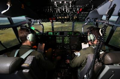 An image of two pilots in a simulator shot from behind with the cockpit in view